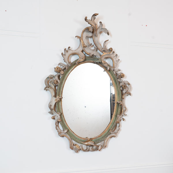 An Italian Rococo Carved, Painted and Parcel-Gilt Oval Mirror