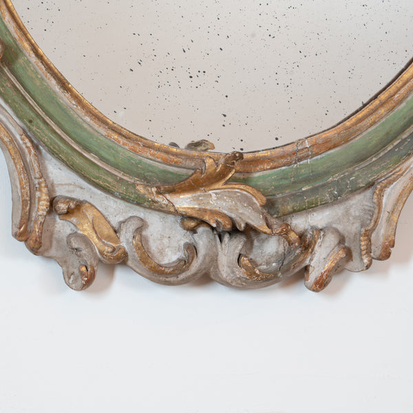 An Italian Rococo Carved, Painted and Parcel-Gilt Oval Mirror