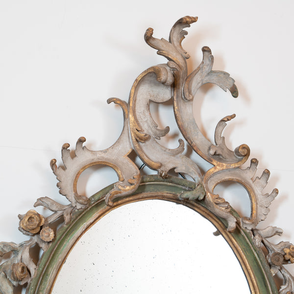 An Italian Rococo Carved, Painted and Parcel-Gilt Oval Mirror