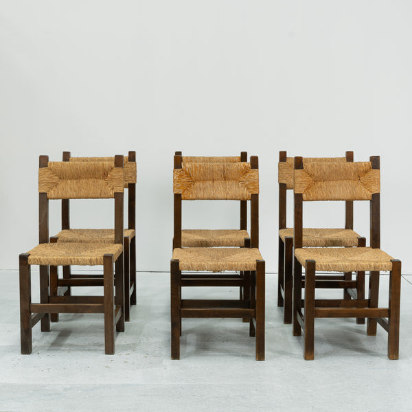 A set of Six rush and beech dining chairs, in the manner of Charlotte Perriand.