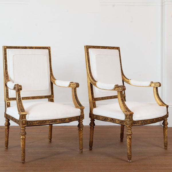 A pair of French Louis XVI style giltwood Fauteuils